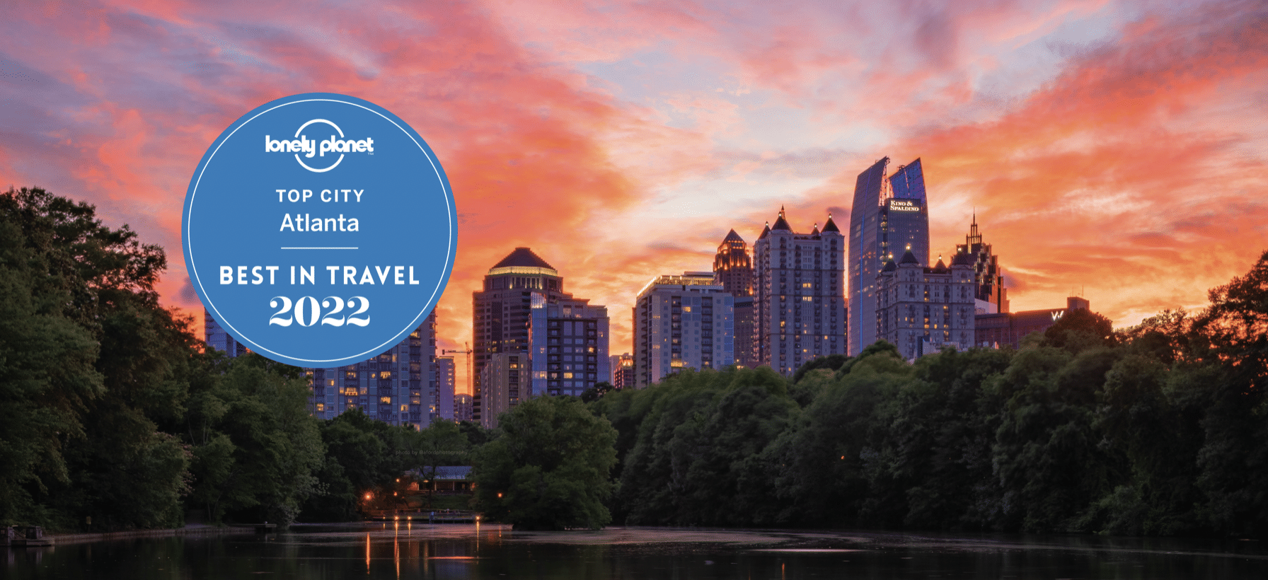 sunset shot of buildings in Atlanta Georgia against a fiery red sky with the Lonely Planet's Best Travel List 2022 badge
