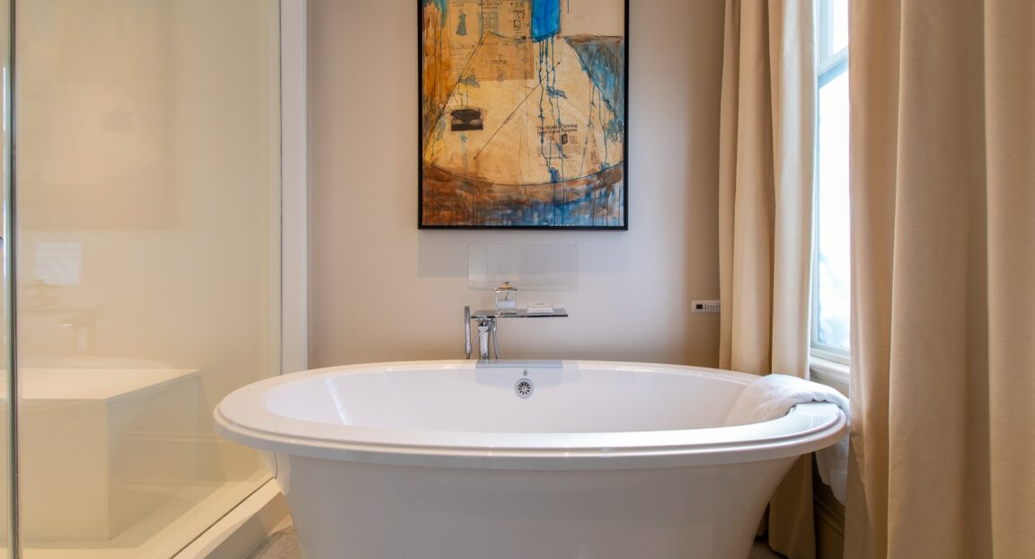 Hinman Suite soaking tub with a colorful framed painting above